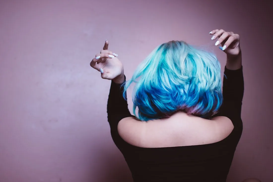 Back view of a client with bright blue and teal colored hair