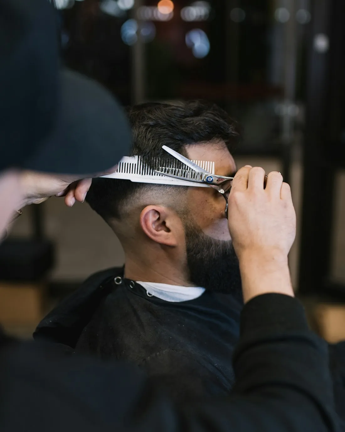 Stylist cutting and shaping a client's hair