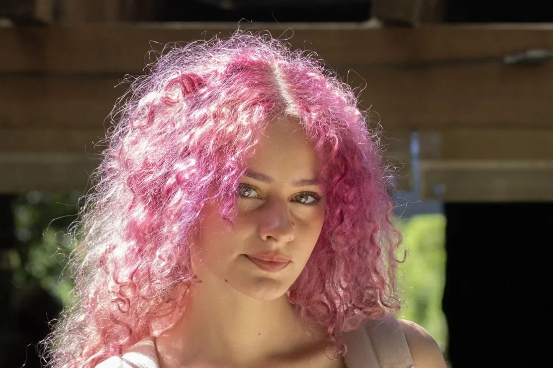Client with vibrant pink curly hair styled out