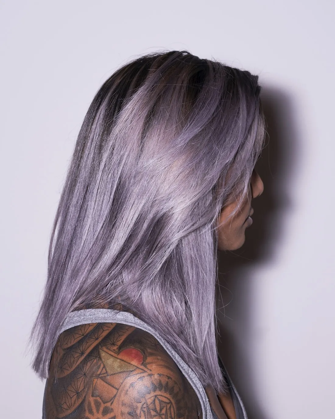 Profile of a client with silvery lavender colored hair against a soft background